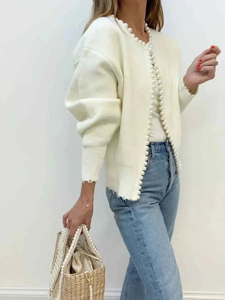 Dettaglio del bordino di perline lungo il collo e l'apertura del cardigan